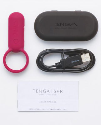 Red silicone vibrating ring with USB charging cable, black storage case, and user manual on white background.