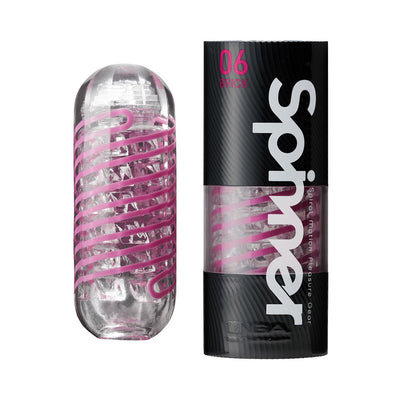 Tenga Spinner Brick male pleasure device with clear casing and pink spiral coil next to black and pink branded packaging.