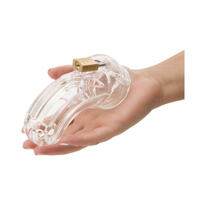 Hand holding a transparent male chastity device with a brass padlock attached.