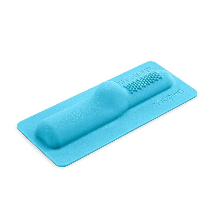 Blue silicone Magic Hide Unicorn attachment with textured nodules and ergonomic raised design on a flat base.