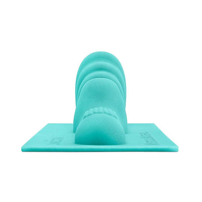 Turquoise silicone attachment with textured bumps and smooth contours designed for premium machine stimulation.