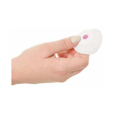 Hand holding a white wireless remote control with a pink power button for the Threesome Wall Banger Rabbit Pink.