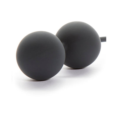 Two smooth black silicone Kegel balls connected by a flexible retrieval cord on a white background.