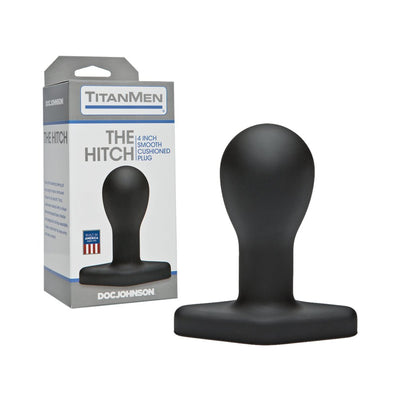 Black matte contoured Titanmen The Hitch butt plug with diamond-shaped base next to its gray and white packaging box.