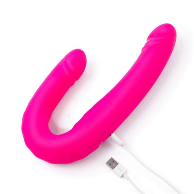 Bright pink flexible silicone couple's vibrator with dual ends and USB charging cable on white background.