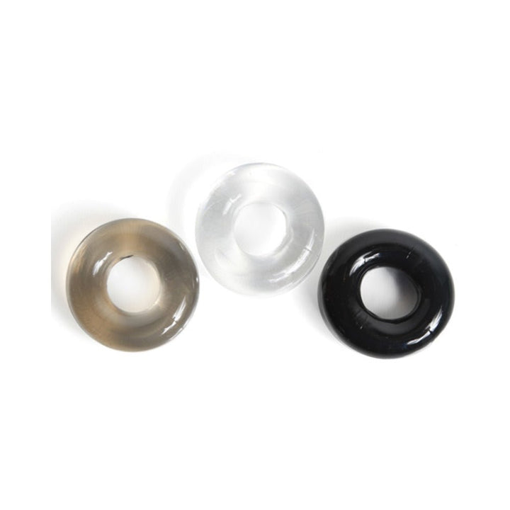 Set of three thick, donut-shaped cock rings in black, clear, and smoke colors on a white background.