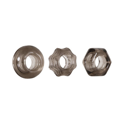 Set of three smoke-colored thick cock rings in circle, star, and hexagon shapes with textured designs.