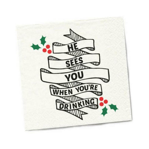 White beverage napkin with black ribbon text reading "He sees you when you're drinking" and green holly with red berries accents.