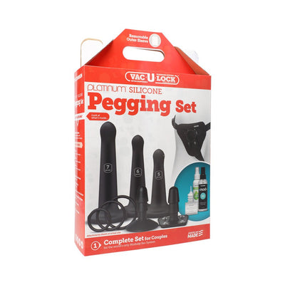 Vac-U-Lock Silicone Pegging Set packaging showing three black silicone dildos, harness, o-rings, lubricant, and toy cleaner.