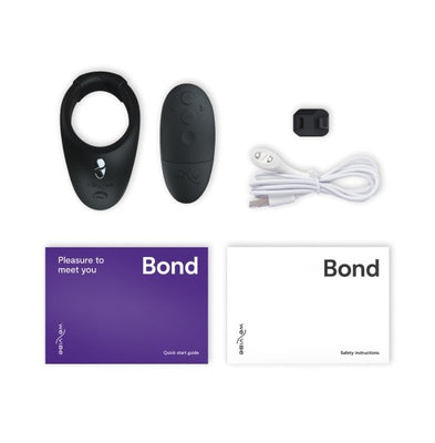 We-Vibe Bond wearable ring with remote, USB charging cable, quick start guide, and safety instructions laid out on white background.