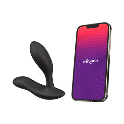 Black We-Vibe Vector+ prostate massager next to a smartphone displaying the We-Vibe app interface.