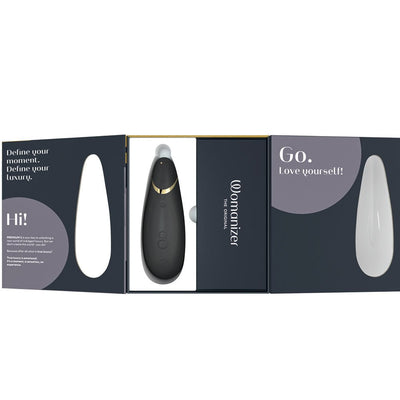 Open Womanizer Premium 2 packaging showing black clitoral stimulator with gold accent and branded compartments.