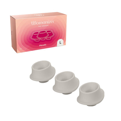 Three gray silicone replacement heads for Womanizer Premium with packaging box in the background.
