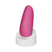 Pink Womanizer Starlet 3 clitoral stimulator standing on a white charging base with control buttons visible.