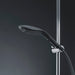 Sleek black Womanizer Wave shower head mounted on chrome shower bar with flexible hose against dark background.