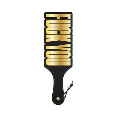 Black paddle with gold "Fuck You" cut-out design and wrist strap detail.