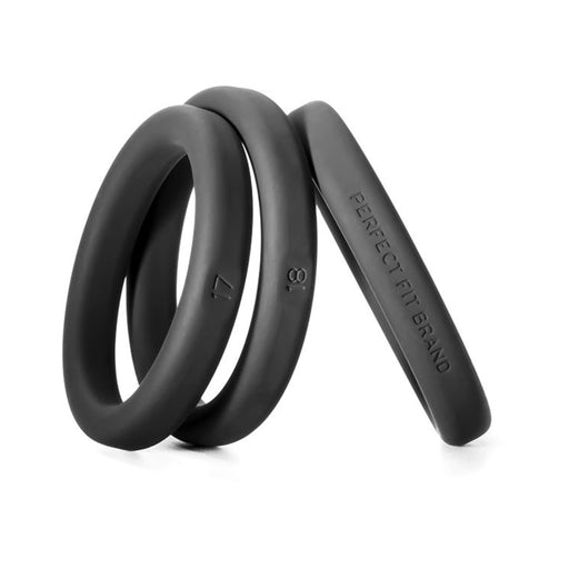 Set of three black silicone rings in medium to large sizes with size markings and smooth finish.