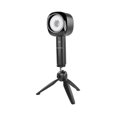 Black Zero Tolerance Let It Slide rechargeable stroker with ergonomic handle on a small tripod stand against white background.