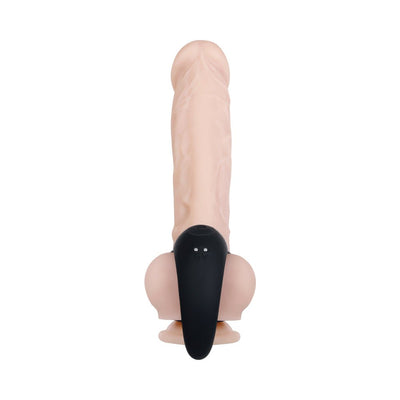 Black vibrating ball cradle worn on a realistic flesh-toned silicone model with textured surface and dual rings.