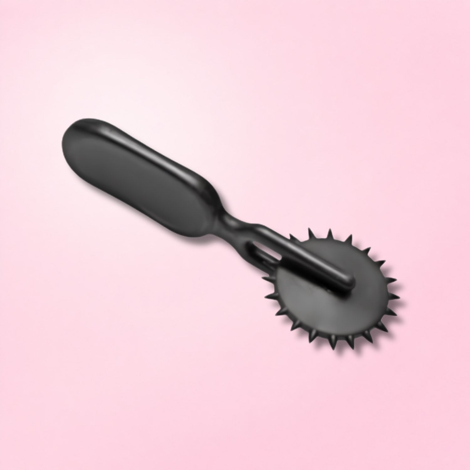 Hand holding a black medical play tool with a spiked wheel against a red textured background.