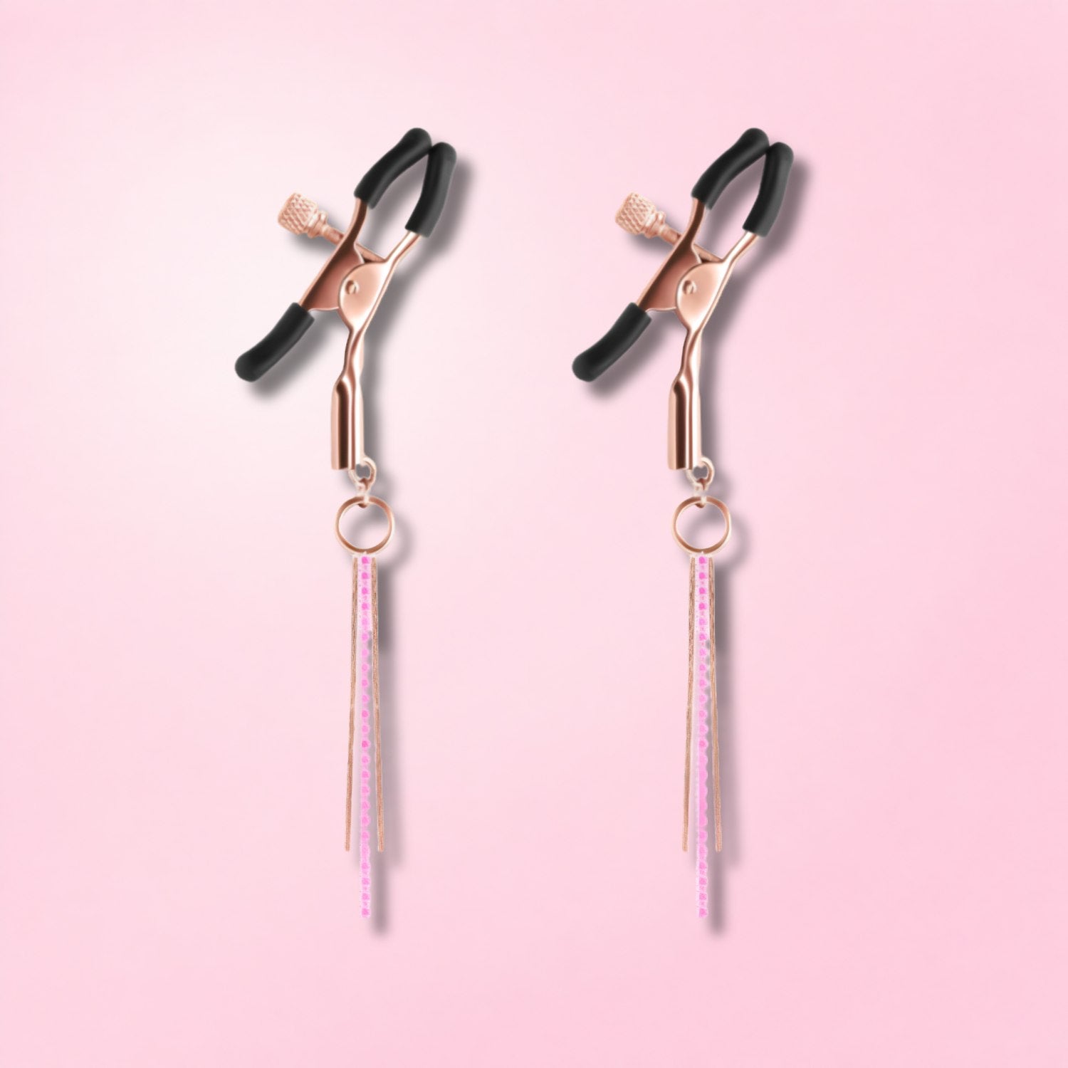 Silver nipple clamps connected by a chain with a black teardrop pendant, displayed on a mannequin torso.