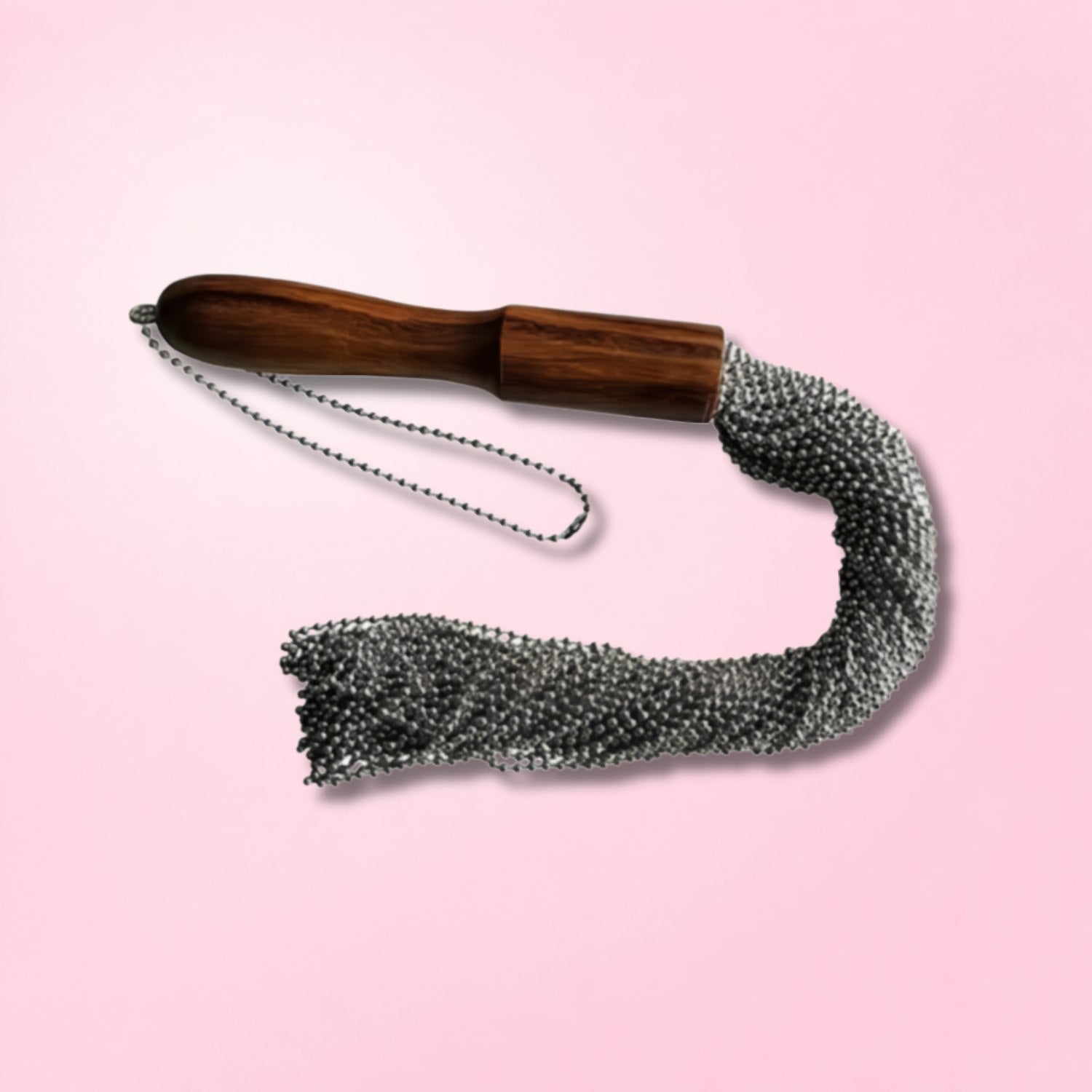 Tattooed woman with hair in bun holding a natural fiber rope flogger over her shoulder against a red textured background.
